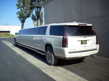Rear exterior view of white Cadillac Escalade limousine